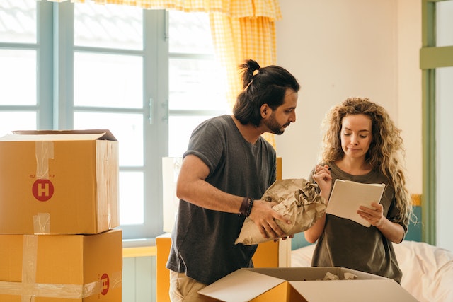 Happy couple packing moving boxes